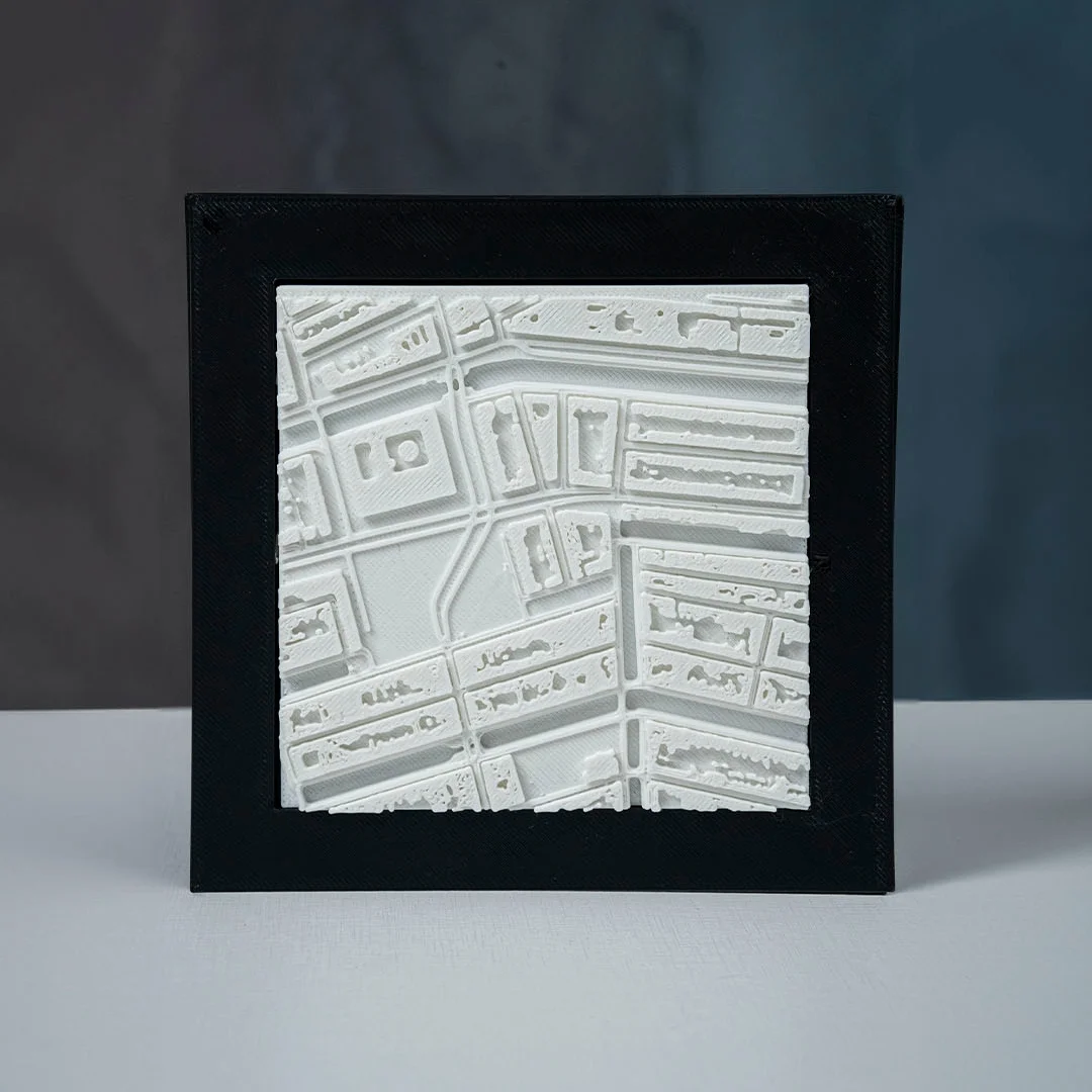 Framed Amsterdam city relief map showing raised buildings and canals.