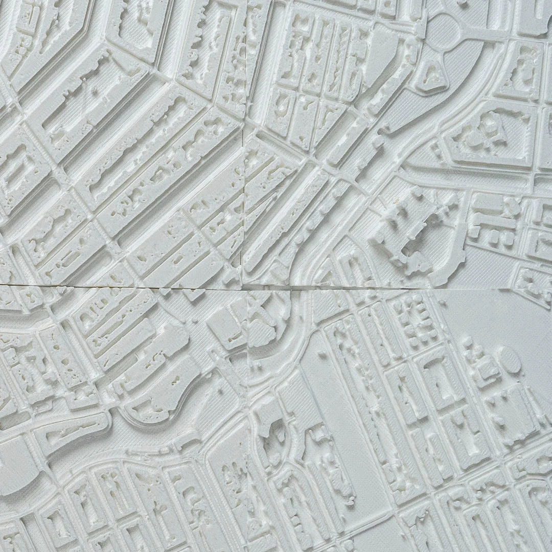 Close overhead view of canal-side buildings in an Amsterdam relief map.