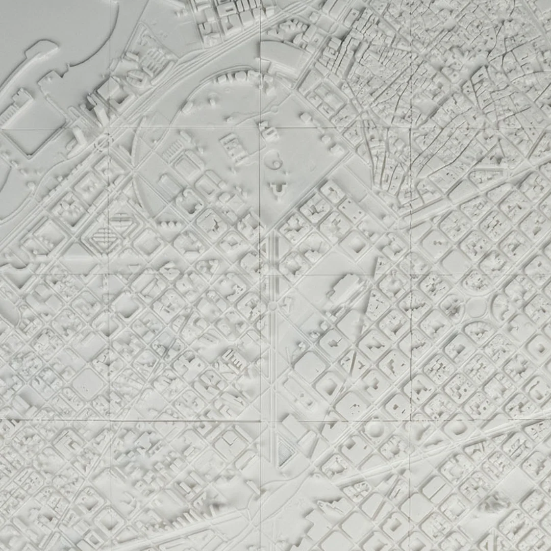 Close overhead view of a Barcelona relief map showing geometric blocks and streets.