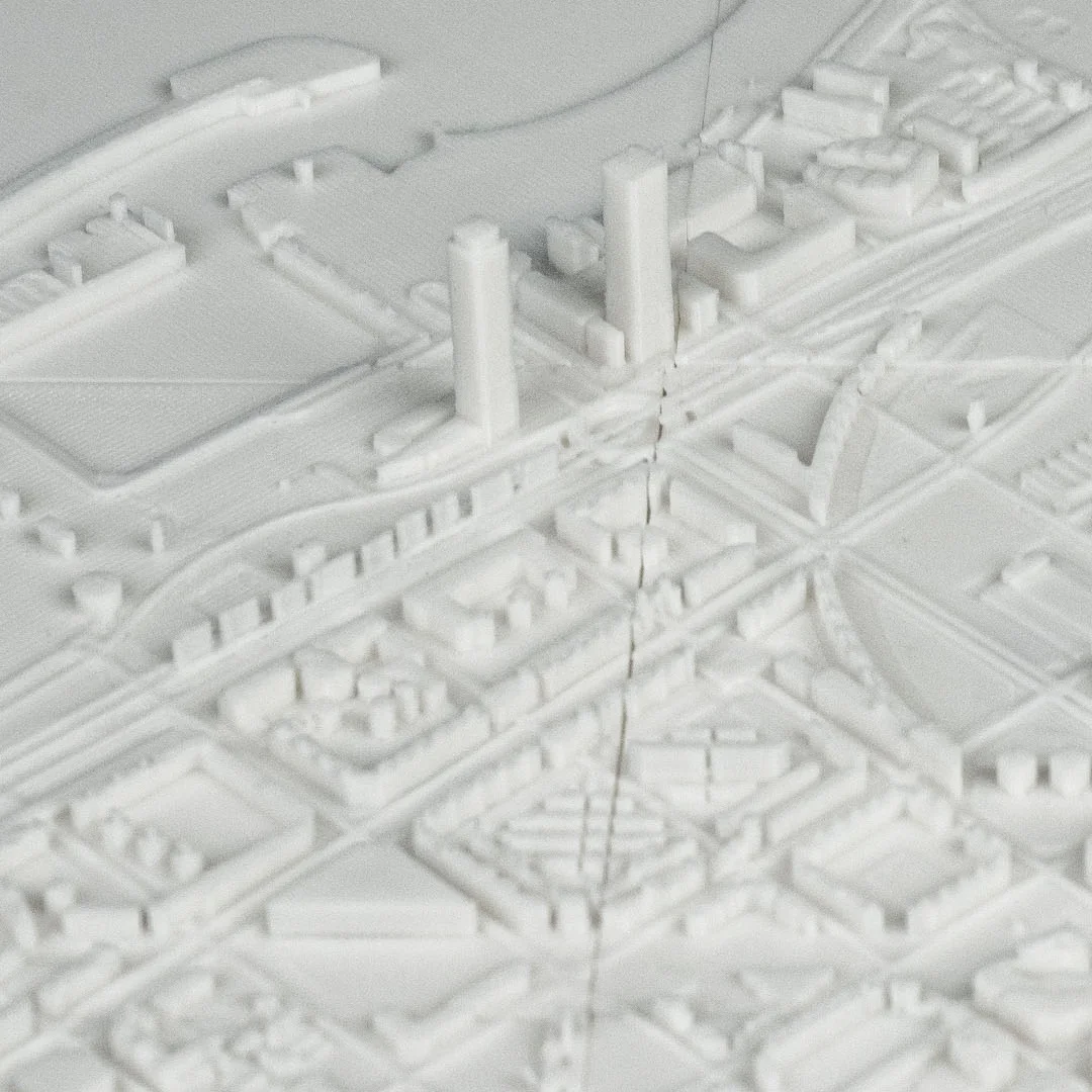 Low angled detail of a Barcelona relief map showing towers and surrounding buildings.