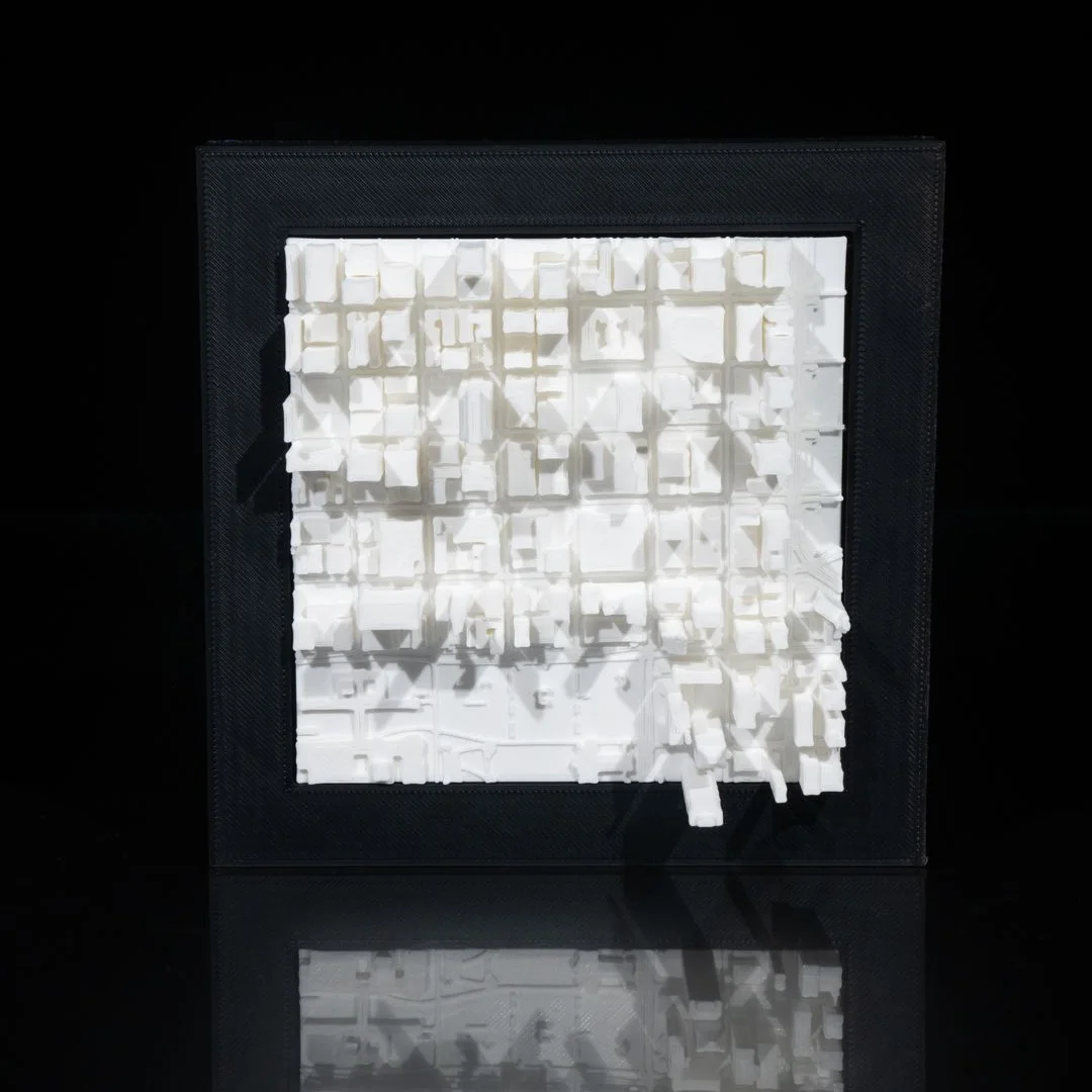 Framed Chicago city relief map showing raised buildings and a street grid.