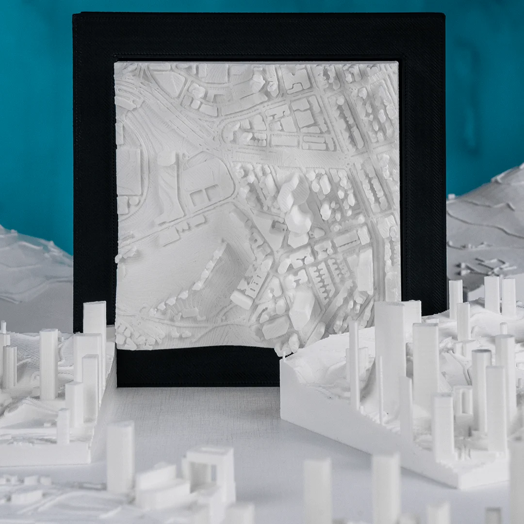 Framed Hong Kong city relief map displayed beside raised city model sections.