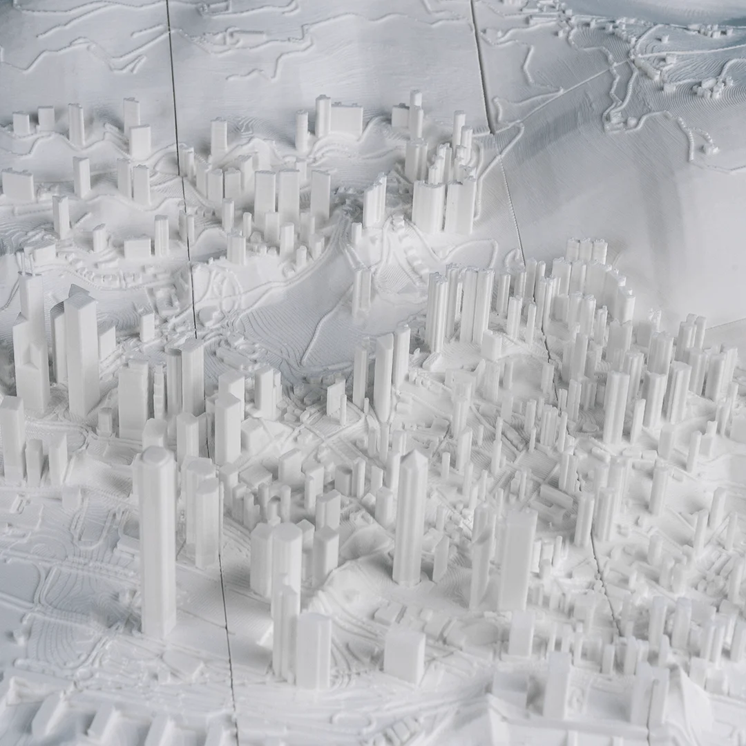Elevated detail of towers and sloping terrain in a Hong Kong relief map.