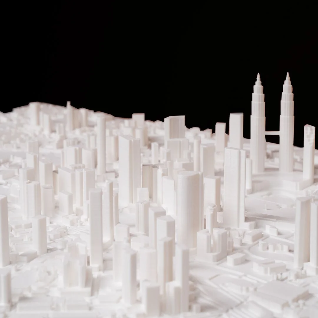 Low view of a Kuala Lumpur relief map showing twin towers and surrounding buildings.