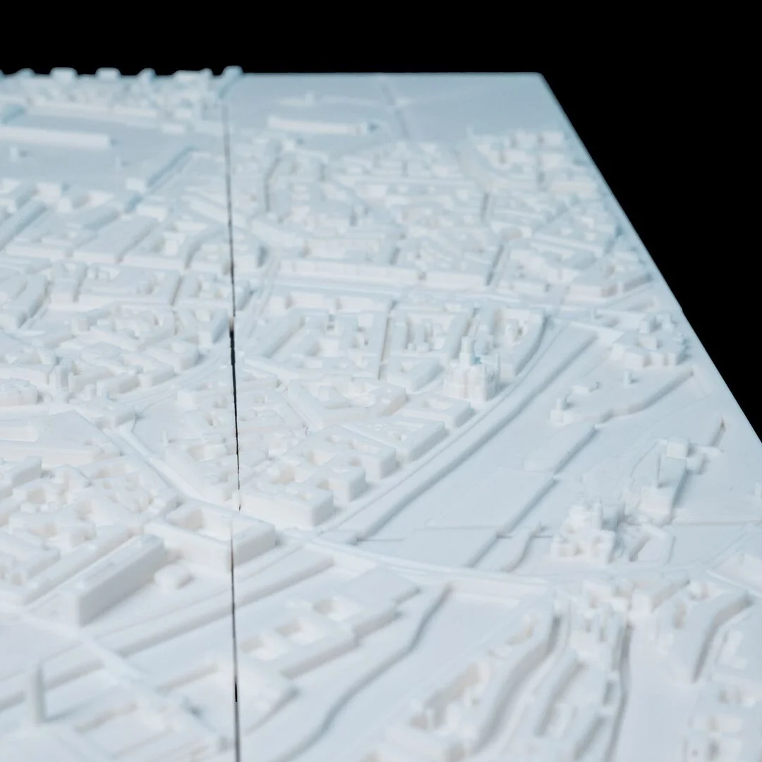 Angled overhead detail of streets and waterways in a Munich city relief map.