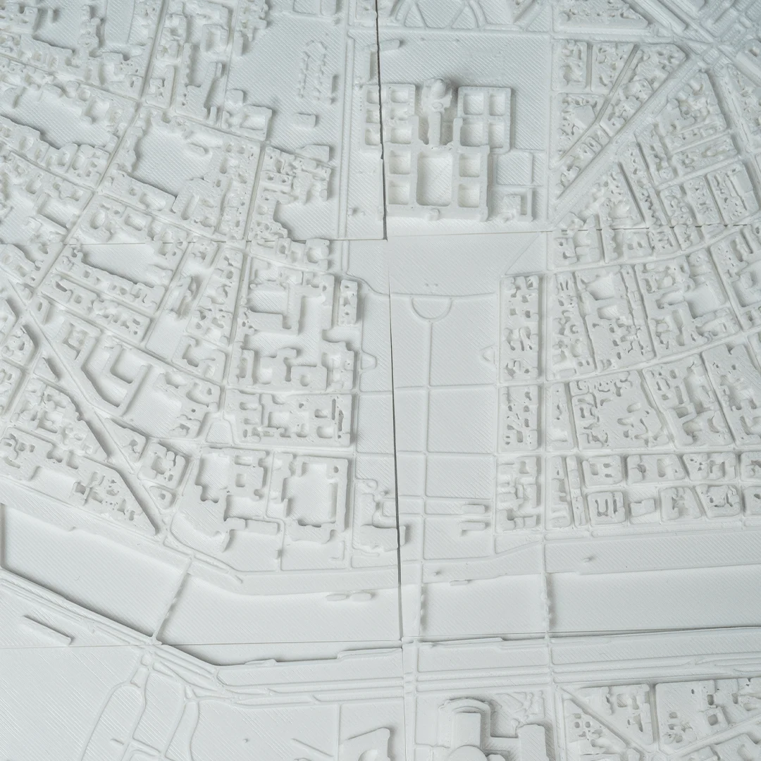 Overhead view of a Paris city relief map showing river bridges and open spaces.