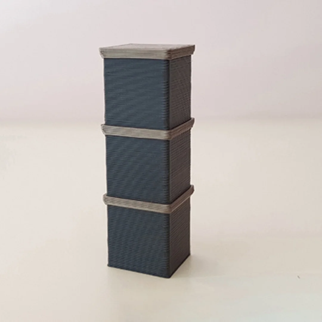 Stacked miniature storage boxes with lids for a 1:50 interior model.