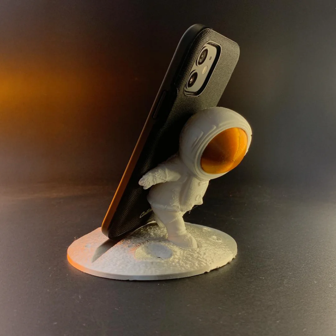 Side view of an astronaut phone holder showing the phone resting against the model.