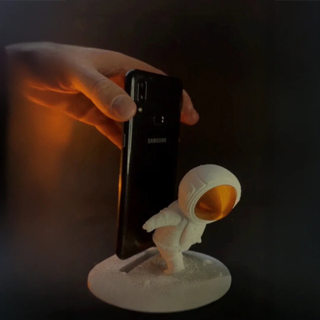A smartphone being placed into the astronaut phone holder.
