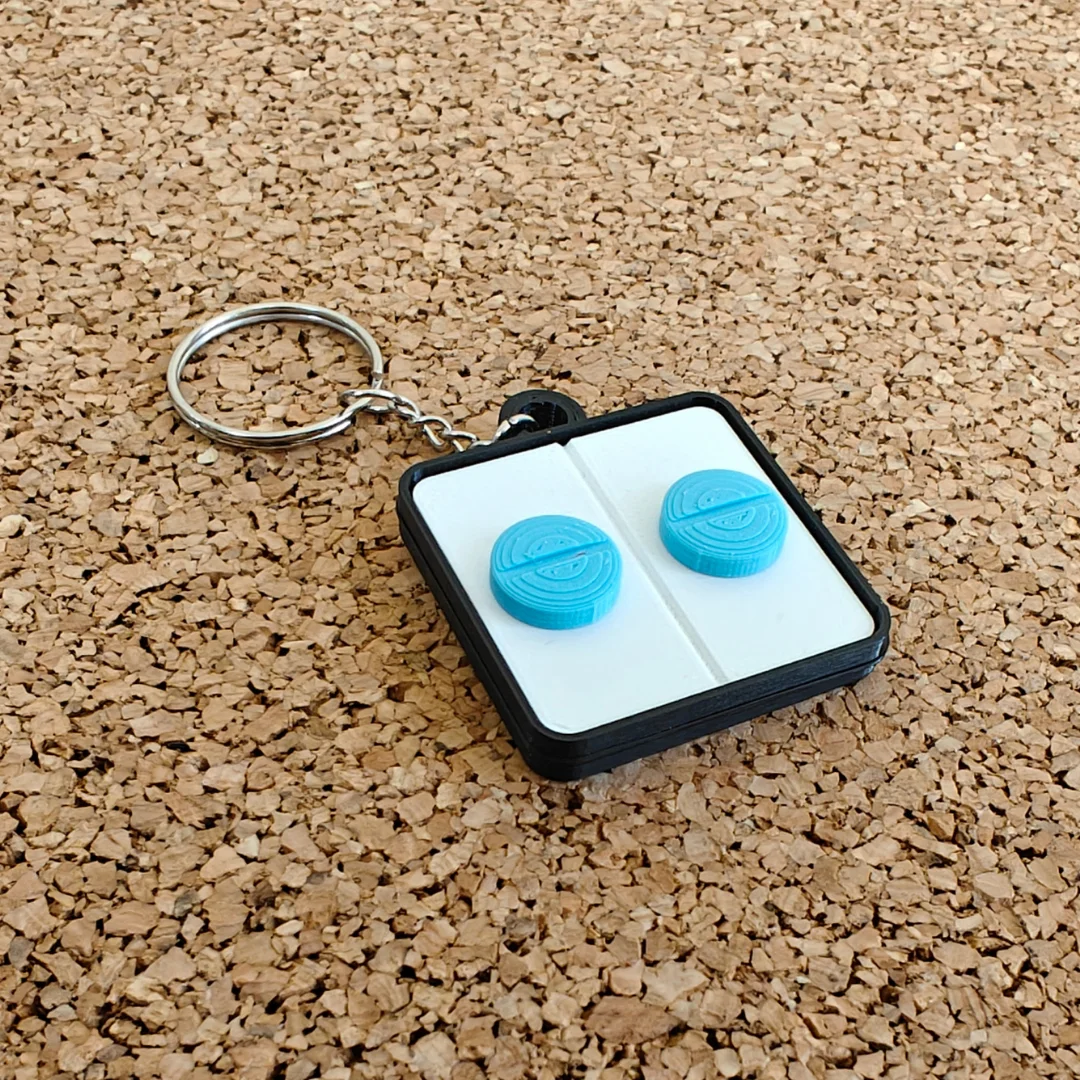 Front view of a rectangular keychain with two round pill shapes and a split ring.