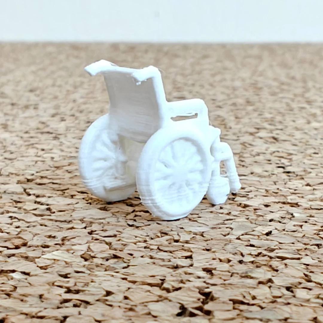 Wheelchair miniature model viewed from behind at 1:50 scale.