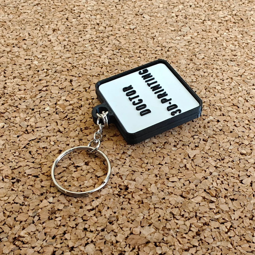 Reverse of the oval pill keychain showing raised custom lettering.