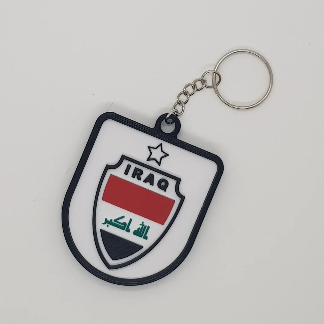Front view of a Iraq football crest keychain with its chain and key ring.