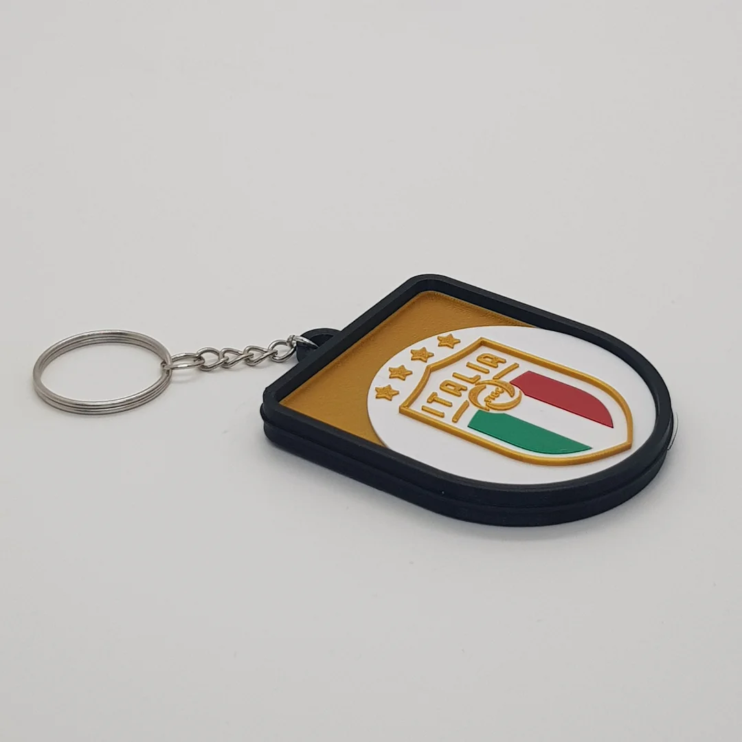 Angled front view of a Italy football keychain showing the raised crest and metal key ring.