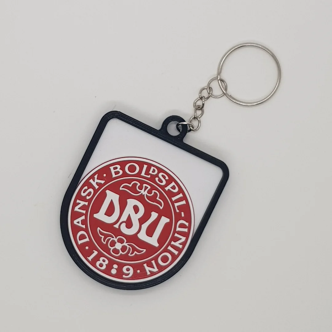 Front view of a Denmark football crest keychain with its chain and key ring.