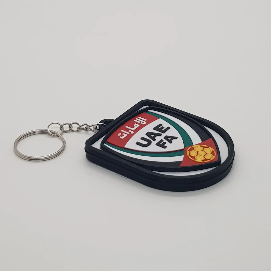 Angled front view of a UAE football keychain showing the raised crest and metal key ring.