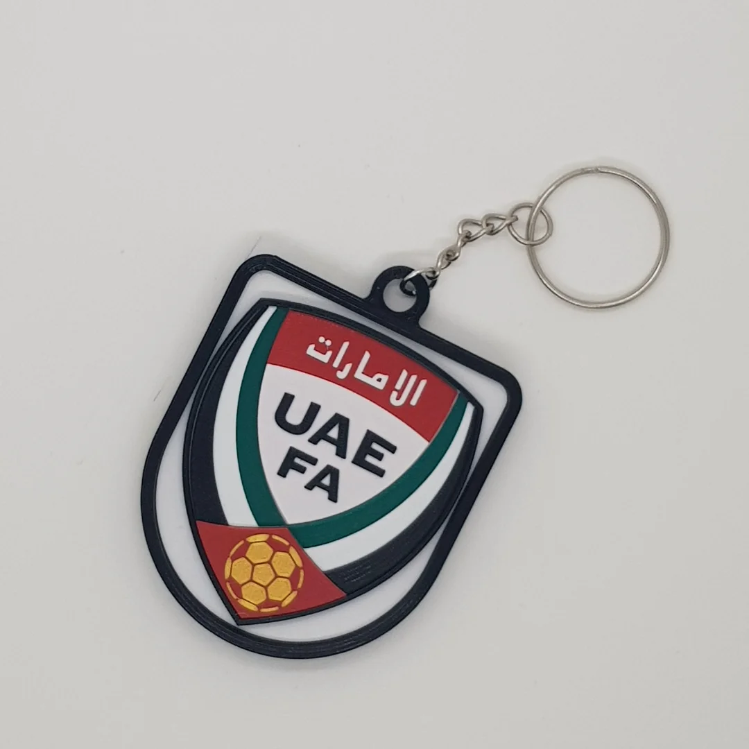Front view of a UAE football crest keychain with its chain and key ring.