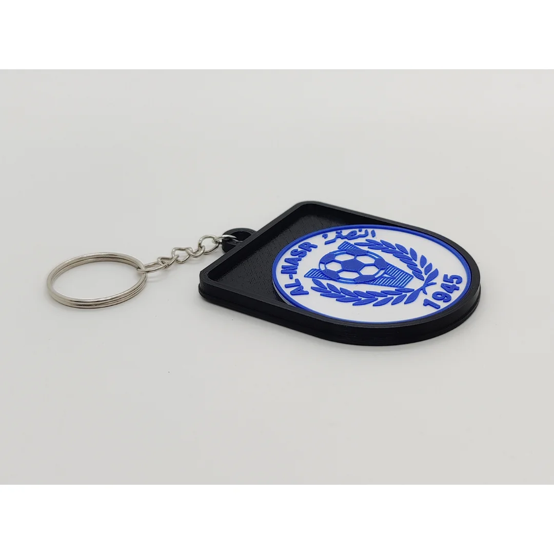 Angled view of the Al-Nasr Emirates keychain showing its raised club crest and key ring.