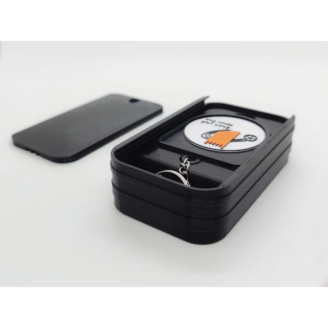 Ajman Club keychain displayed inside an open presentation box.
