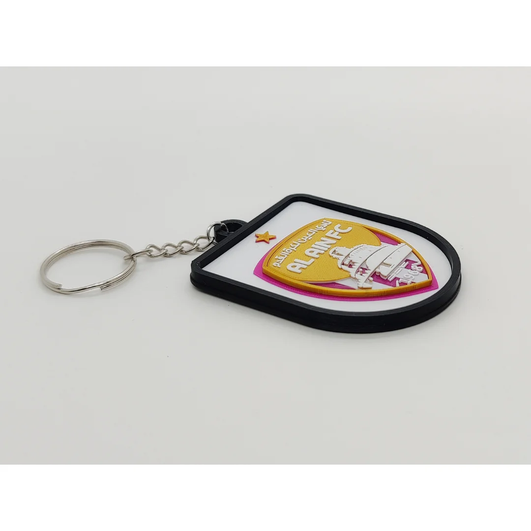 Angled view of the Al-Ain FC keychain showing the club crest and metal key ring.