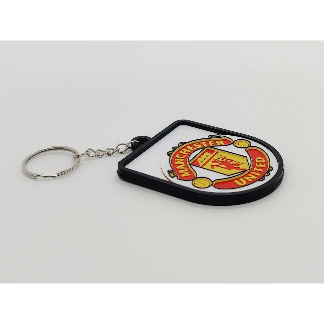 Angled view of the Manchester United FC keychain showing the club crest and metal key ring.