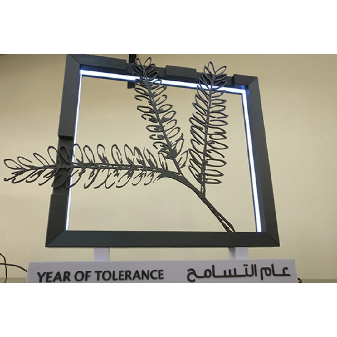 Front angled view of an illuminated Year of Tolerance sculpture and its display stand.