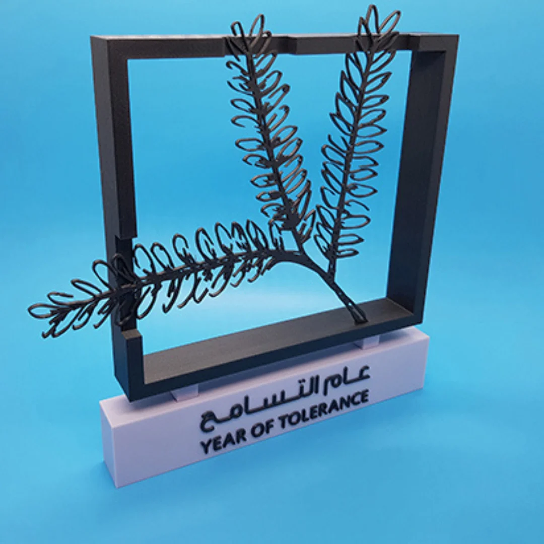 Angled view of a freestanding Year of Tolerance branch sculpture in a square frame.