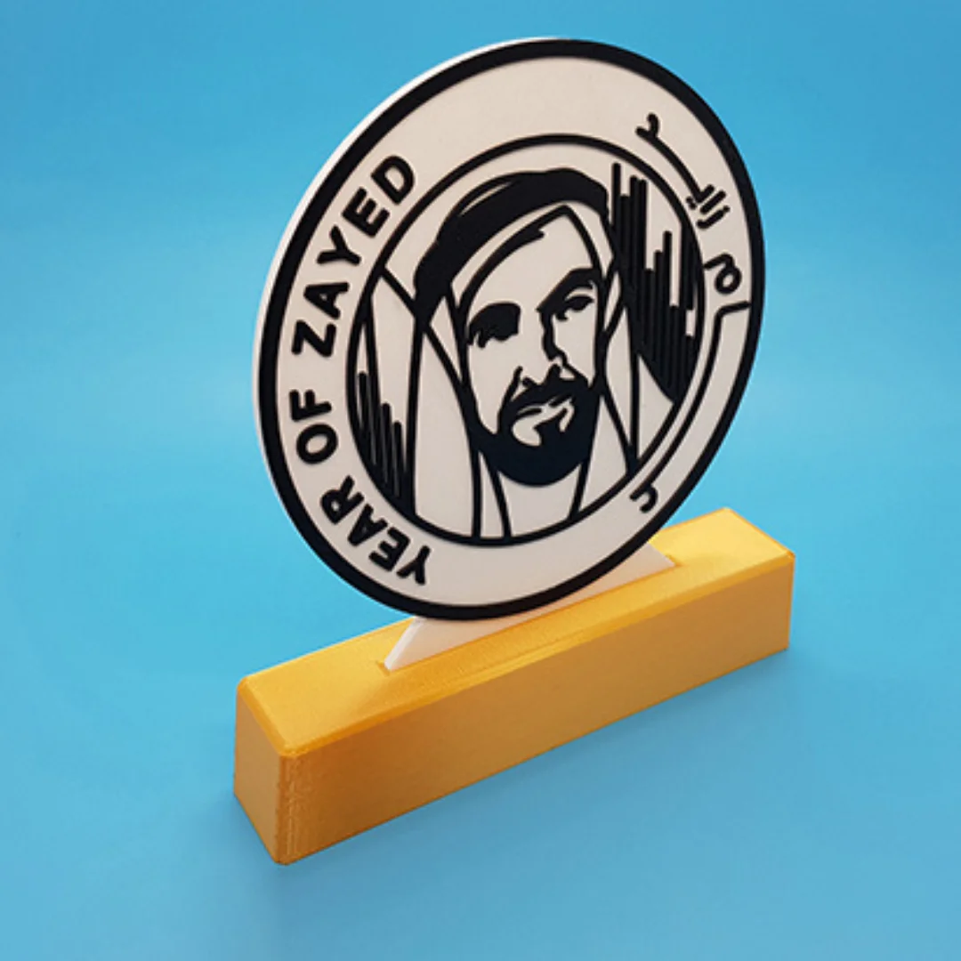 Angled view of a circular Year of Zayed portrait sculpture on a rectangular stand.