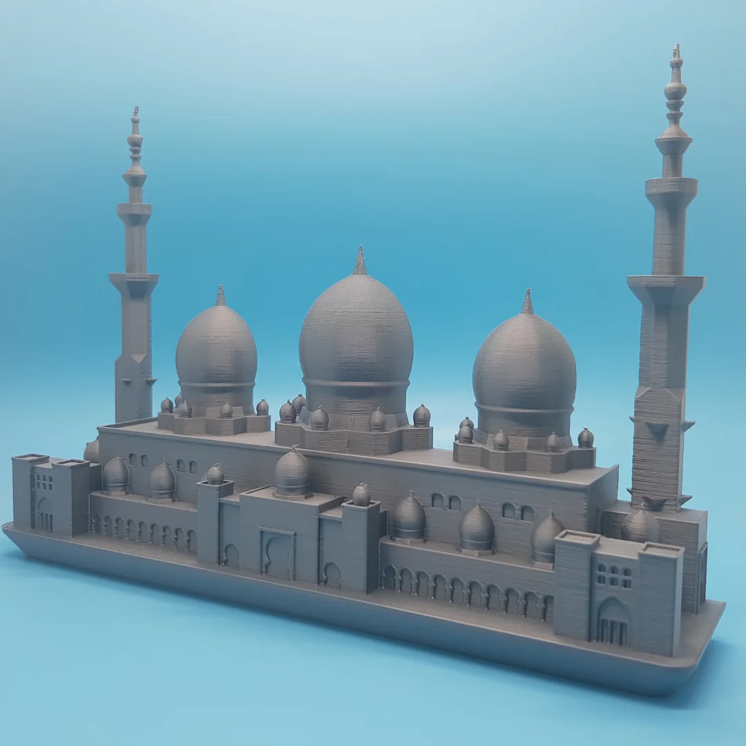 Angled view of a Sheikh Zayed Mosque elevation model with three large domes and two minarets.
